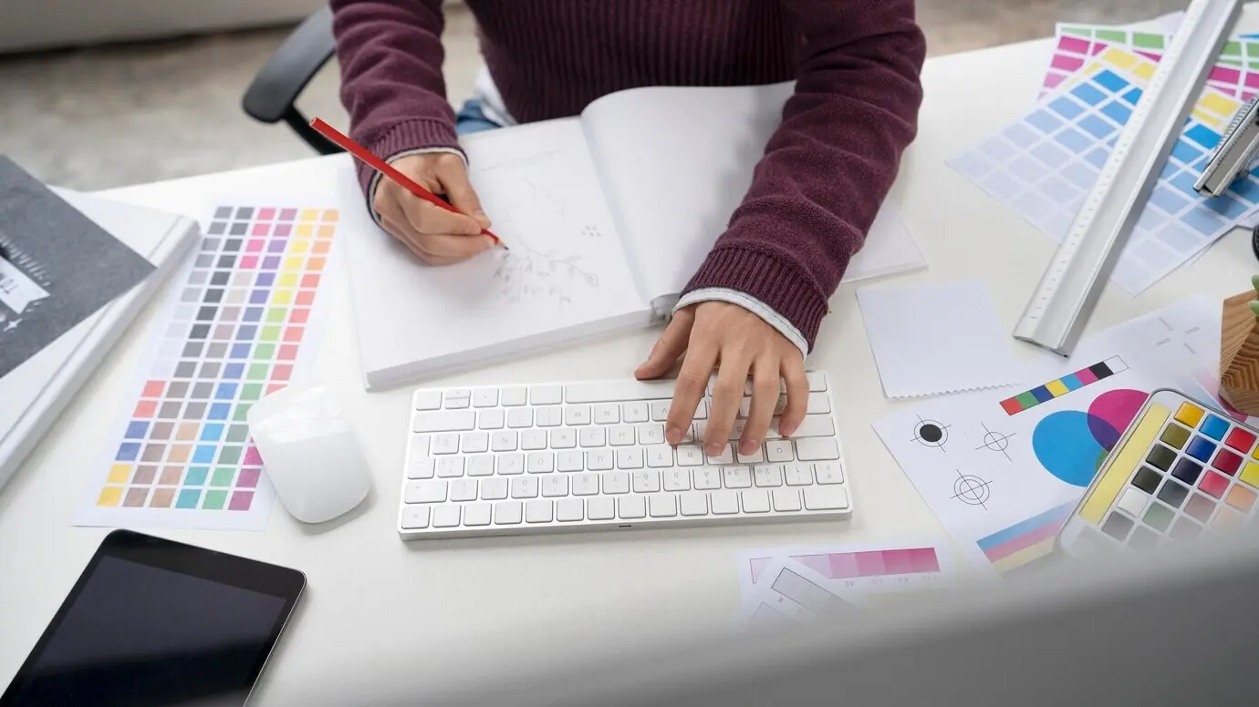 Grafikdesigner, der ein Logo in einem Notizbuch entwirft.